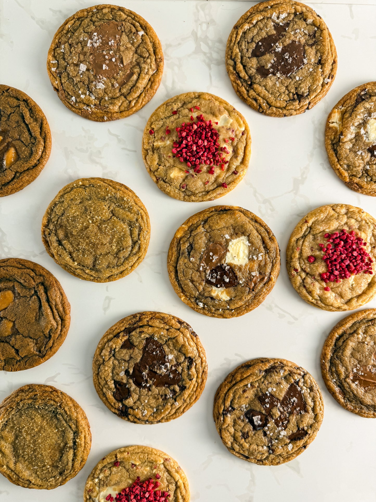 Six Half Three bakery-style cookies showing the full flavour range — triple choc, dark chocolate, milk chocolate, white chocolate and raspberry, espresso toffee, and Earl Grey and orange