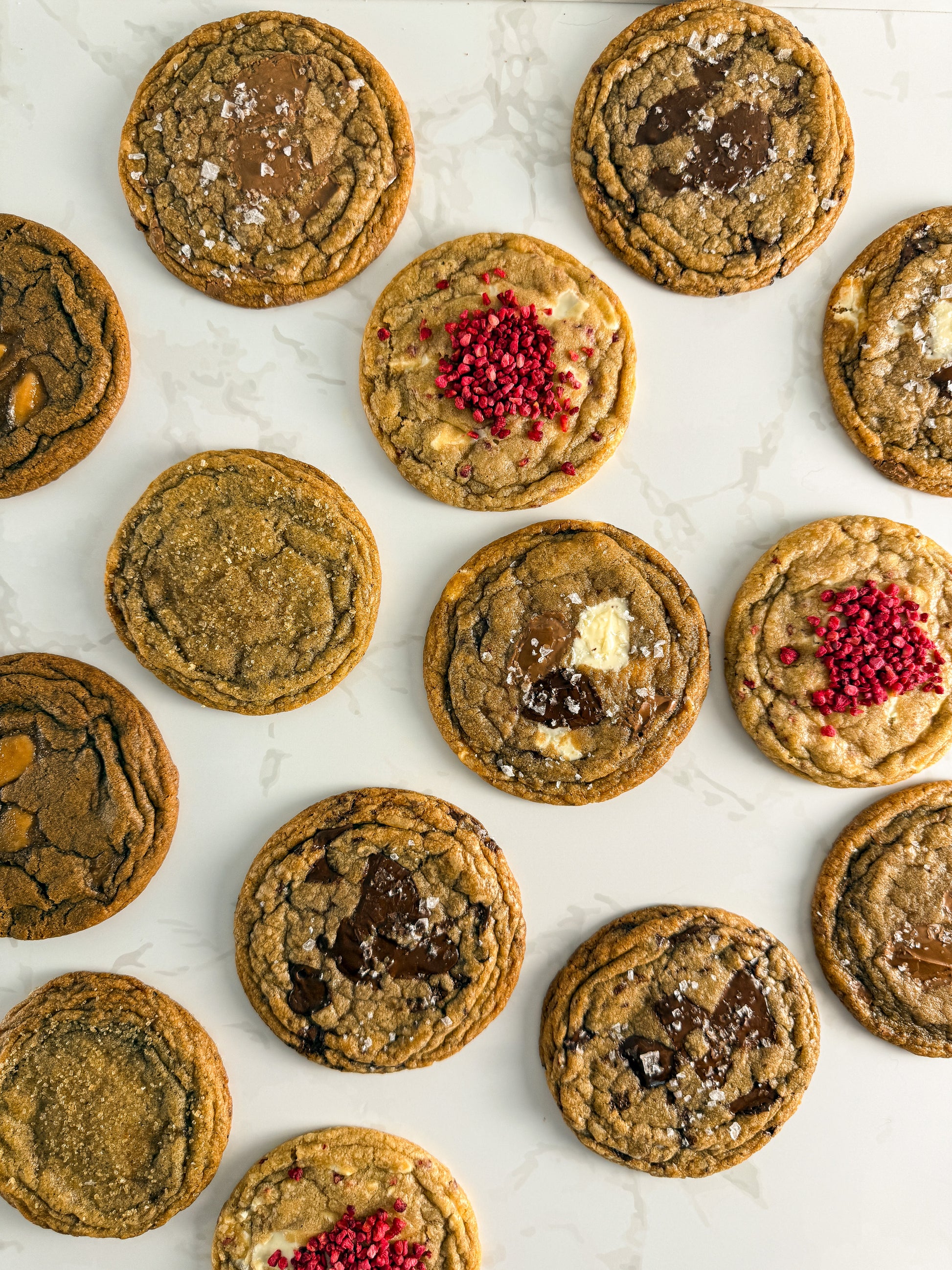 Six Half Three bakery-style cookies showing the full flavour range — triple choc, dark chocolate, milk chocolate, white chocolate and raspberry, espresso toffee, and Earl Grey and orange