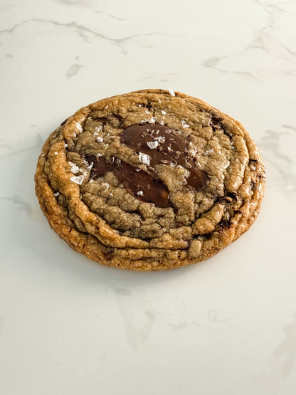 Half Three dark chocolate and sea salt cookie from above at an angle, showing crinkled edges and chewy centre