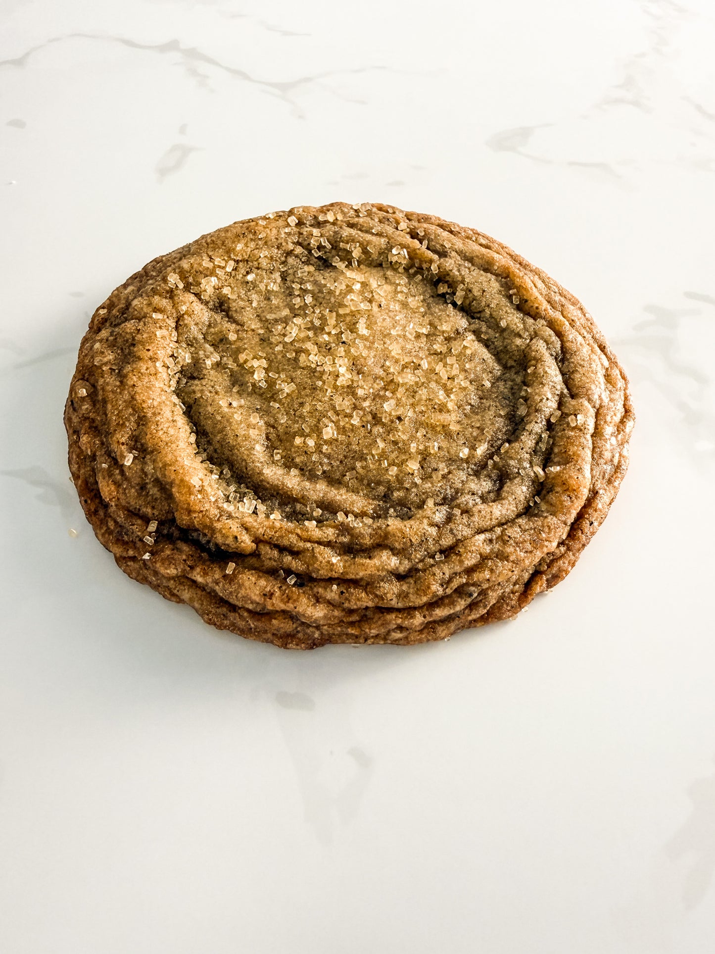 Half Three Earl Grey and orange cookie from above at an angle, showing delicate texture and sugar topping