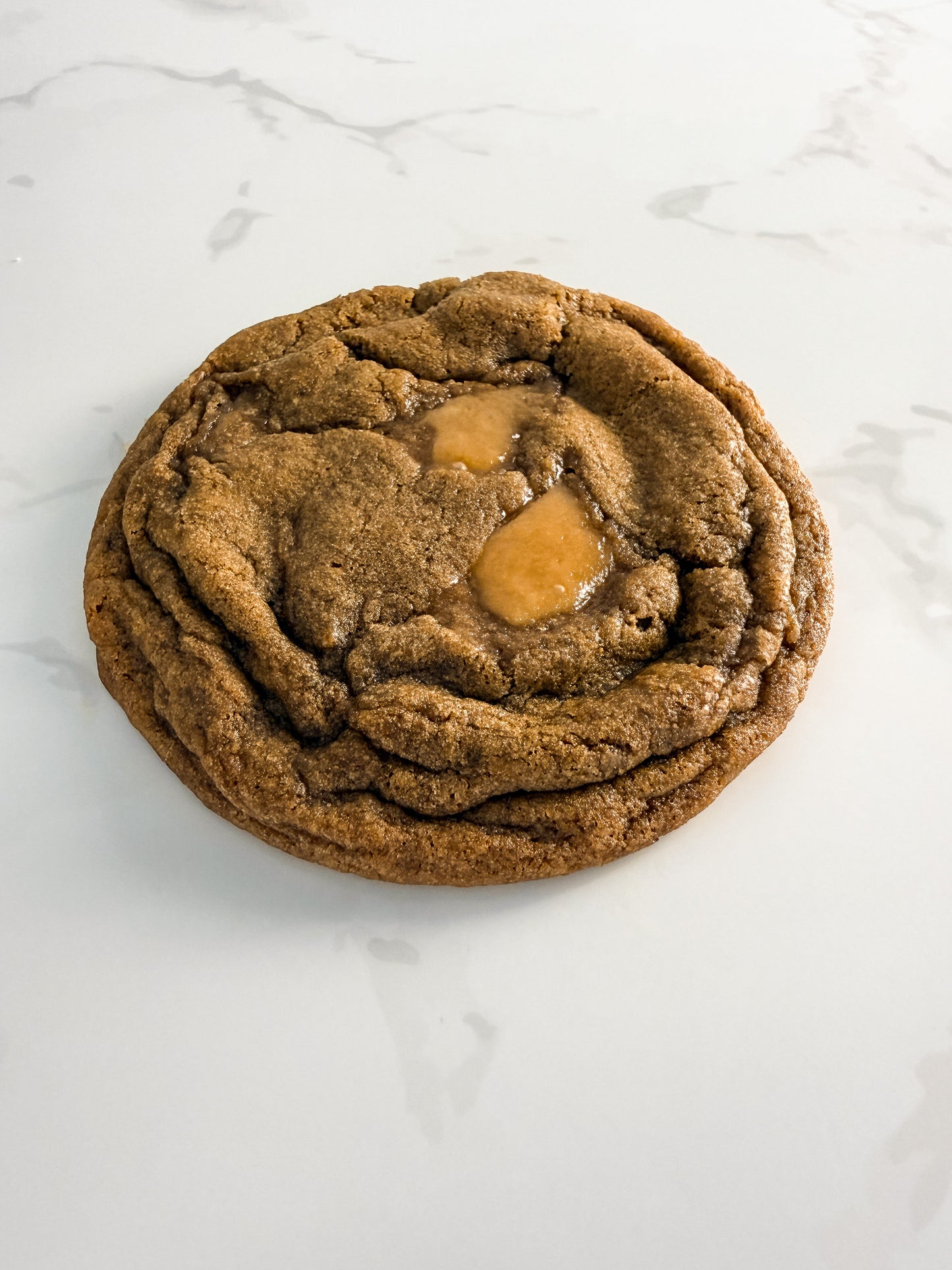 Half Three espresso toffee cookie from above at an angle, showing caramelised toffee and crinkled edges