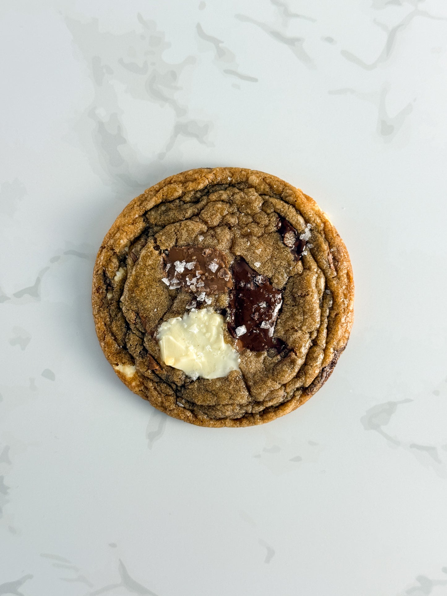 Half Three triple chocolate cookie with dark, milk, and white chocolate pools and Maldon sea salt flakes
